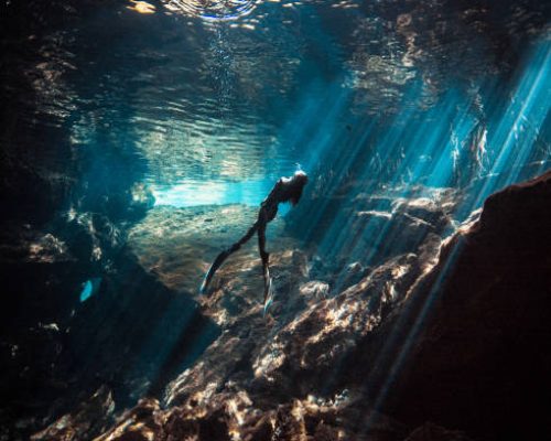 A Japanese Freediver swimming and enjoying the beauty of a Mexican Cenote